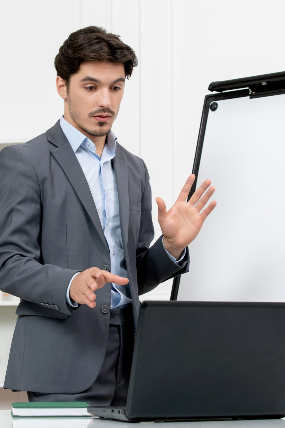 teacher-smart-instructor-grey-suit-classroom-with-computer-whiteboard-explaining-lecture